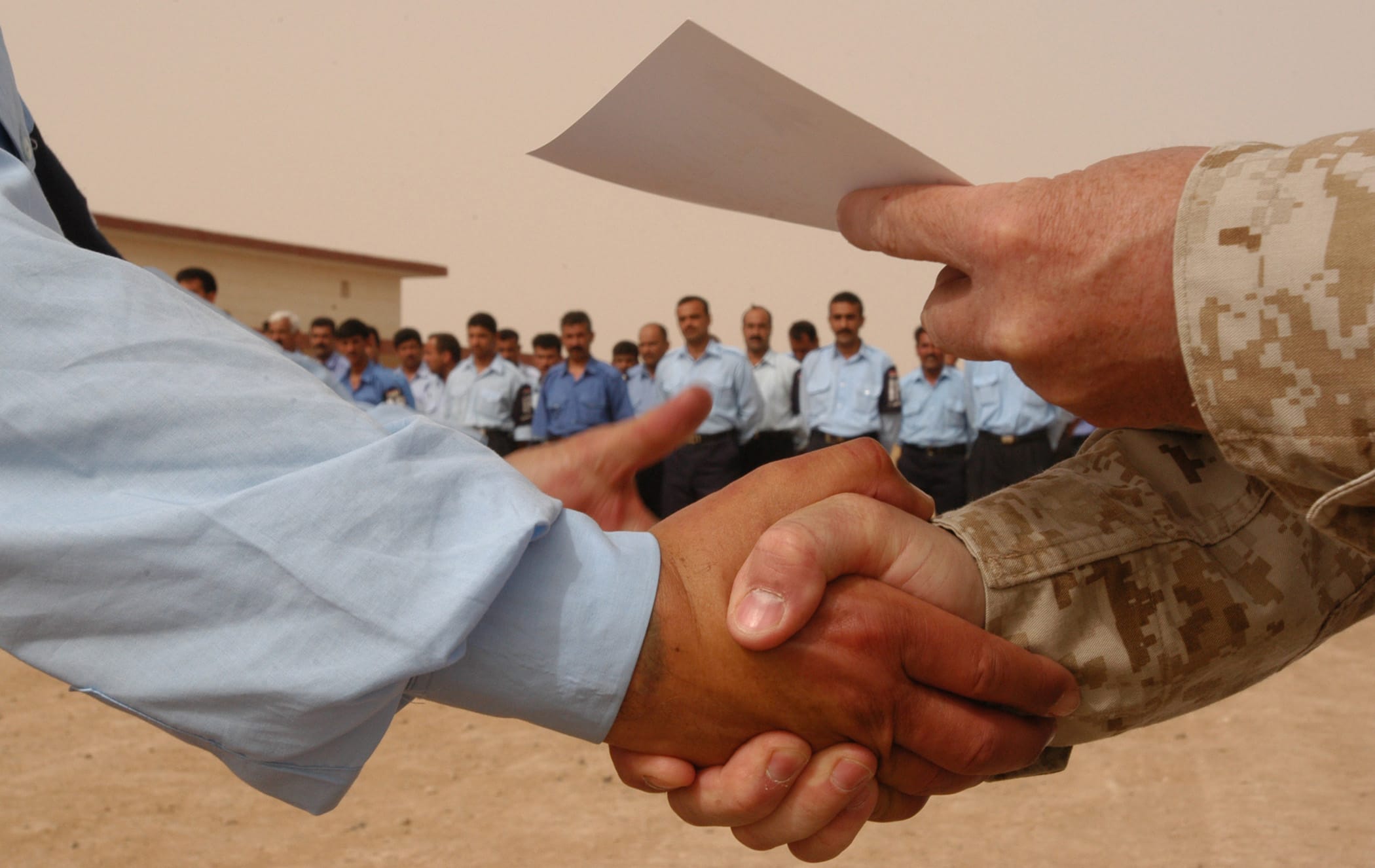 Handshake exchanging a document between professionals, symbolising partnership and professional development in counselling training, Liverpool
