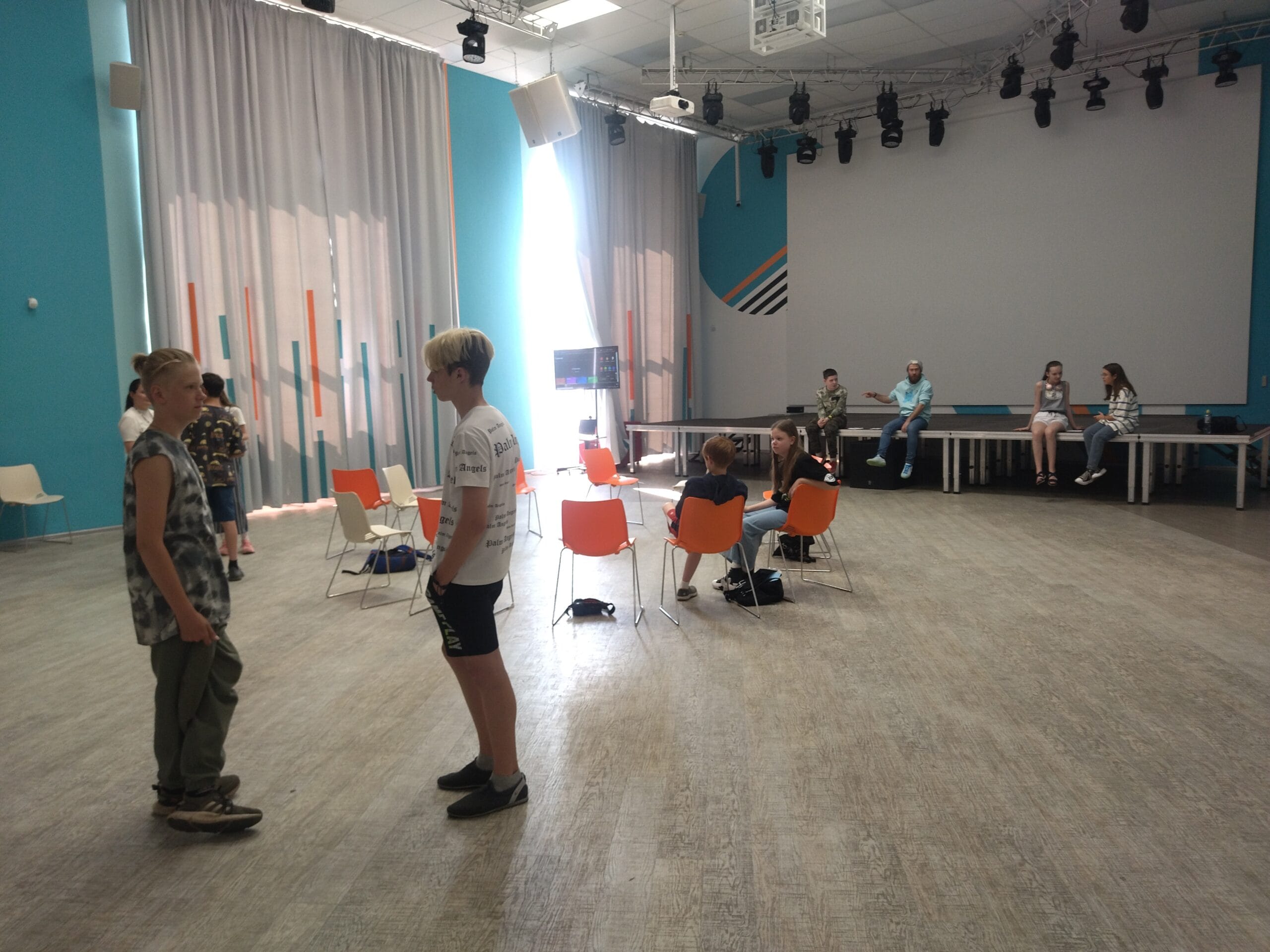 Equality, Diversity and Inclusion in Counselling Practice 2 Young people and tutor in a bright training room with orange chairs and stage — counselling training environment, Liverpool