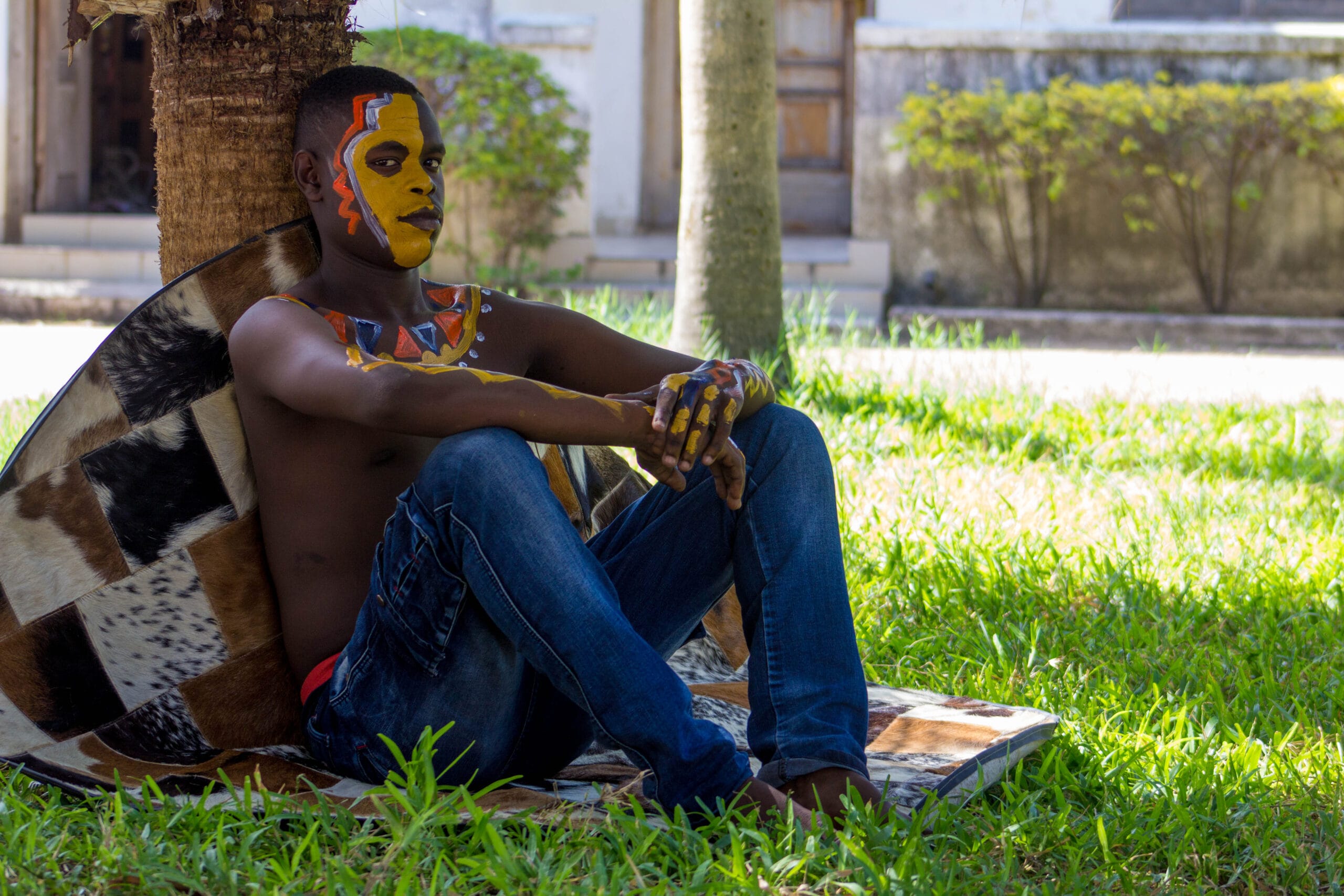 Regression in Hypnotherapy: Theory, Technique, and Responsible Practice 10 Person with colourful face and body paint seated by a tree, relaxed outdoor scene promoting wellbeing and counselling training Liverpool